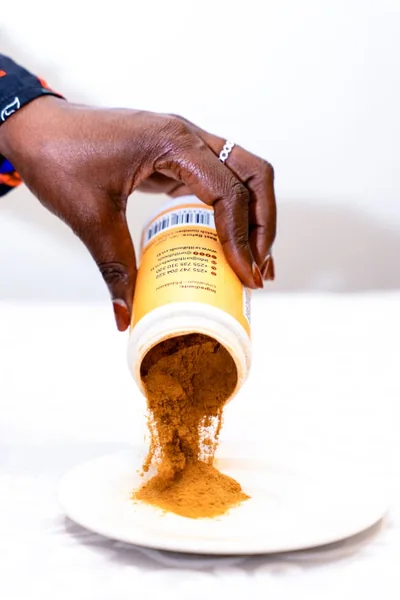 Turmeric poured from a Urithi Foods jar onto a plate