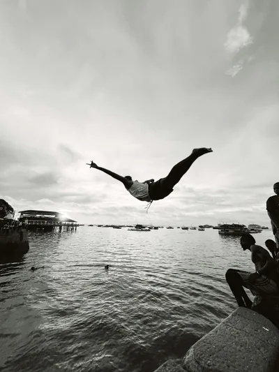 A young diver mid-air above the Indian Ocean on the Tanzanian coast