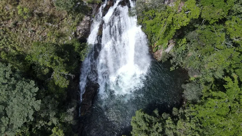 Aerial view of a waterfall plunging into a forest pool at Mpanga-Kipengere