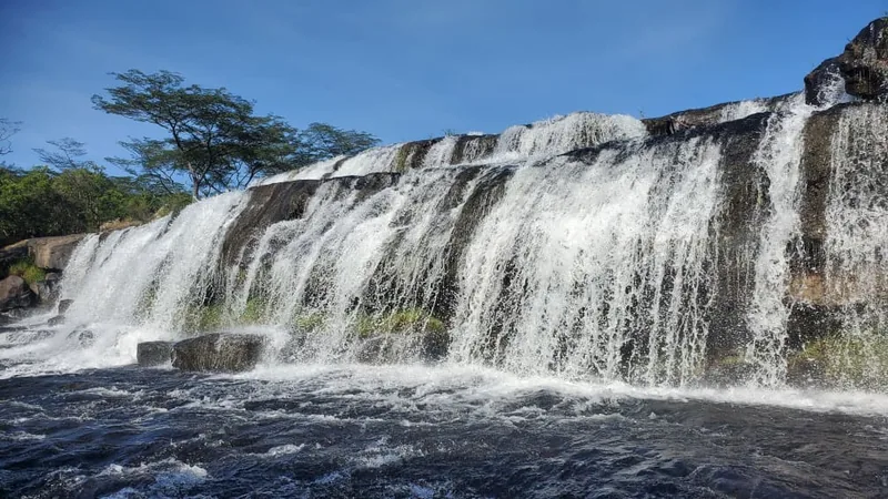 A wide waterfall at Mpanga-Kipengere Game Reserve under a clear sky