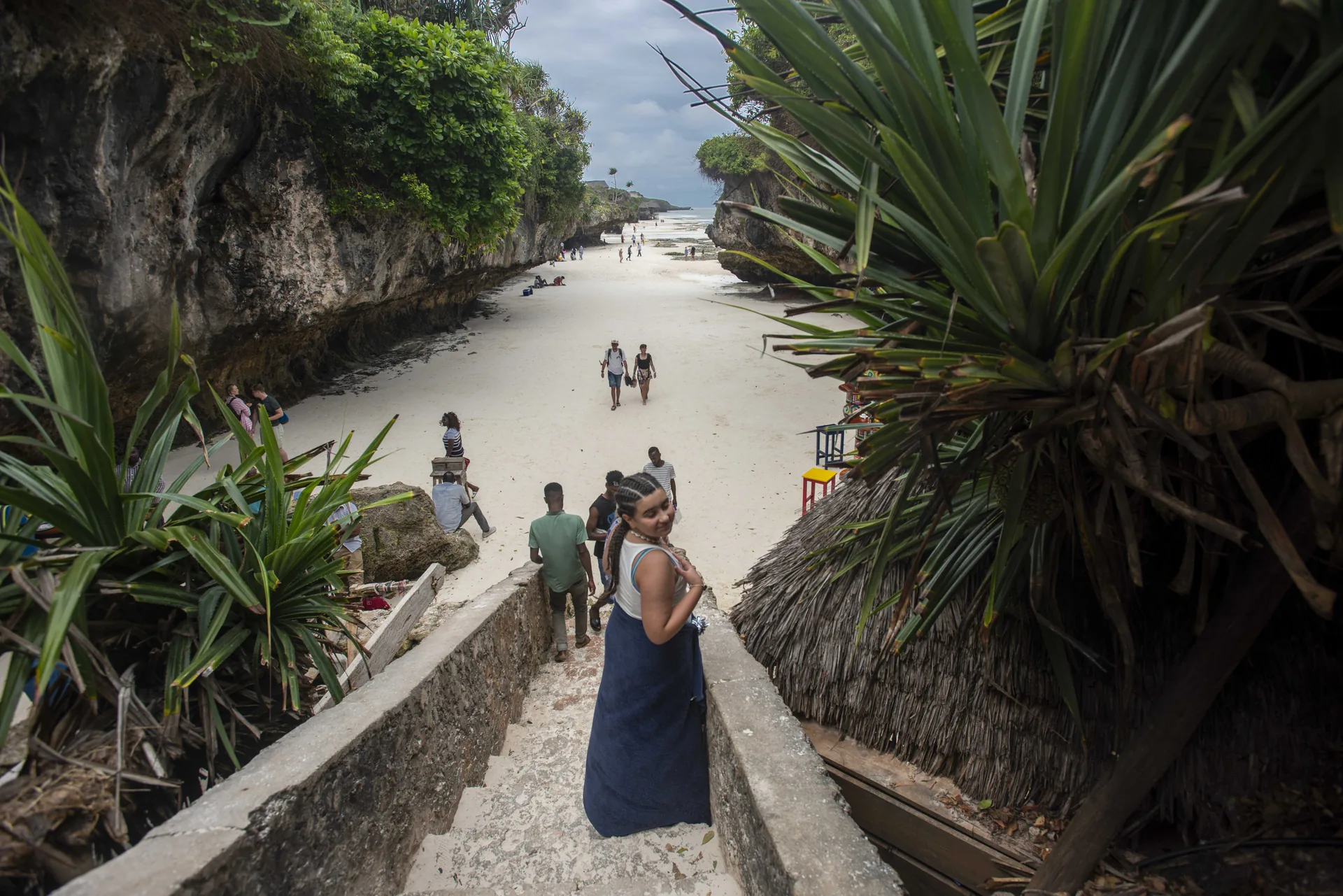 Travellers walking a shaded coastal path on Zanzibar